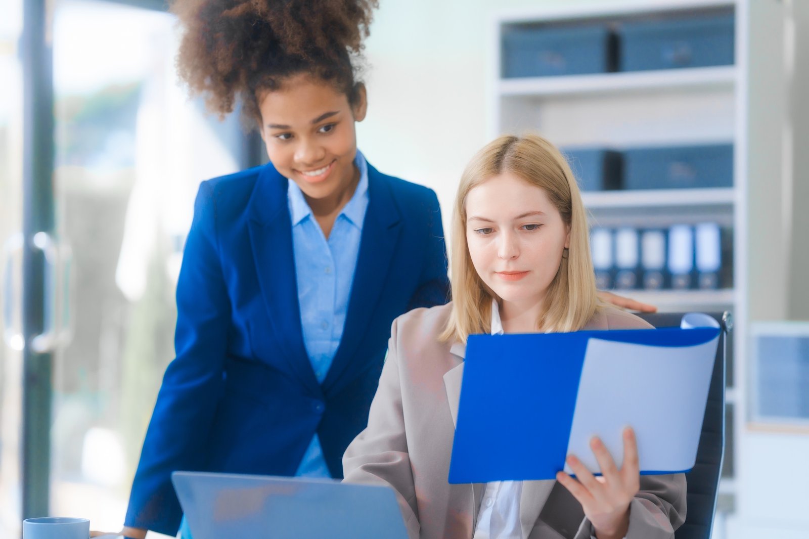young Russian woman in a suit works in an office, analyzing charts and strategizing on projects.