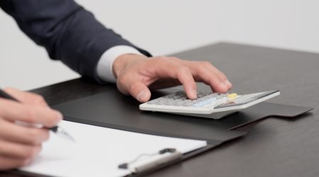 Hands of a businessman calculating an estimate with a calculator